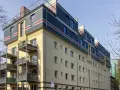 Modernes Mehrfamilienhaus mit Balkonen und auffälliger Fassadengestaltung im **Vorort**.