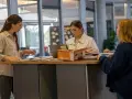Studentinnen im Journalismus Studium arbeiten an einem Projekt. Sie sichten Unterlagen und diskutieren.