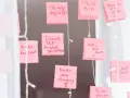 Rosa Haftnotizen mit inspirierenden Affirmationen wie "Think BIG" und "Never stop dreaming" hängen an einer Lichterkette.