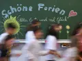 Schöne Ferien! Kinder freuen sich auf die Osterferien 2026 in NRW. Die Tafel zeigt Sonne, Blumen und ein Herz.