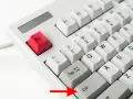 Die rote Esc-Taste und die Ctrl-Taste auf einer weißen Tastatur. Ein roter Pfeil zeigt auf die Ctrl-Taste.