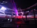 Spektakuläre Blitze zucken in einem **Faradayschen Käfig**, während ein Mann sicher darin steht. Laserstrahlen durchschneiden die Dunkelheit.