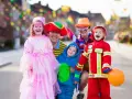 Fröhliche Familie in Kostümen feiert Fasching. Wann sind Faschingsferien in Baden-Württemberg 2026?