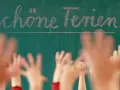 Schöne Ferien! Kinderhände recken sich erwartungsvoll dem Tafelbild entgegen, bereit für die Sommerferien NRW 2029.