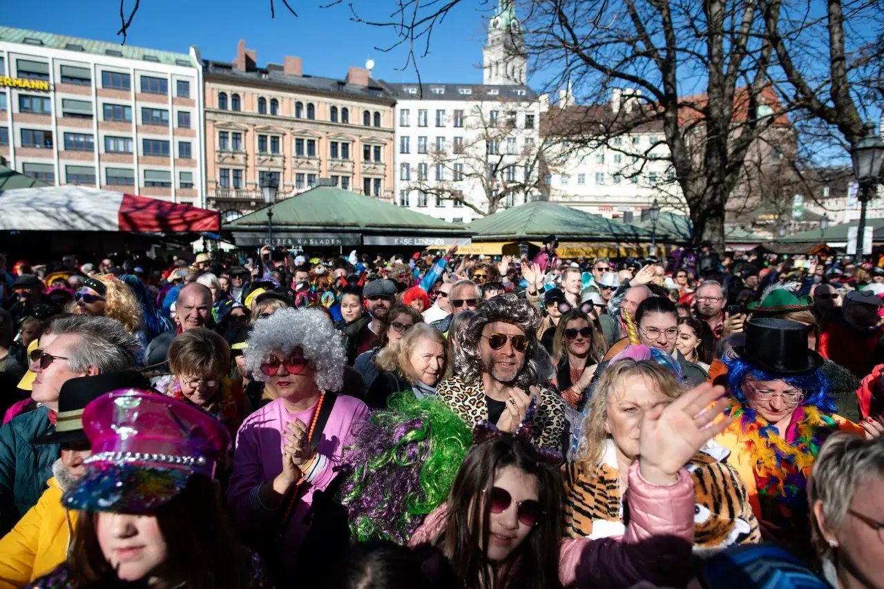 Bunte Kostüme und fröhliche Gesichter beim Fasching in Bayern 2027. Eine ausgelassene Menge feiert ausgelassen.