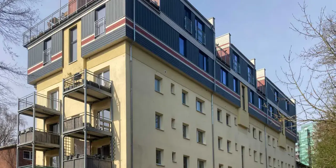 Modernes Mehrfamilienhaus mit Balkonen und auffälliger Fassadengestaltung im **Vorort**.