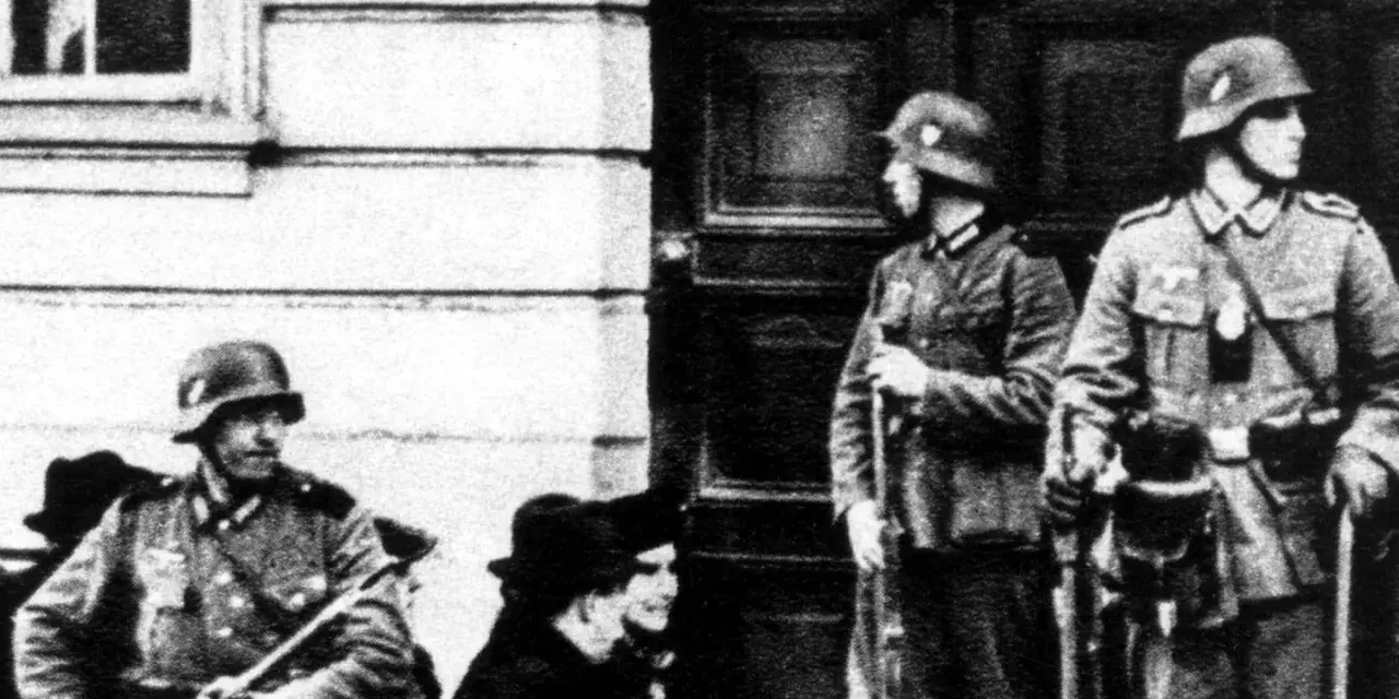 Soldaten der Gestapo stehen Wache. Ein Mann mit Gewehr im Vordergrund, zwei weitere im Hintergrund.