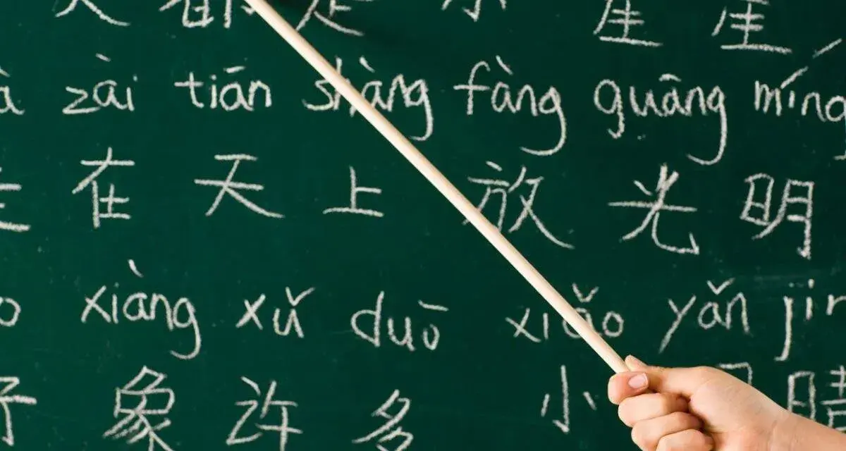 Kreide auf Tafel: Chinesische Schriftzeichen und Pinyin. Manche sagen, Chinesisch sei die schwerste Sprache der Welt.