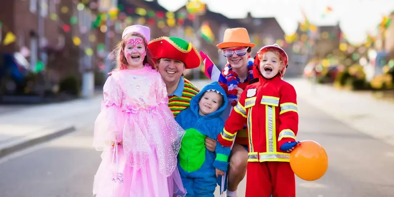 Fröhliche Familie in Kostümen feiert Fasching. Wann sind Faschingsferien in Baden-Württemberg 2026?
