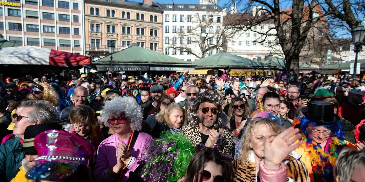 Bunte Kostüme und fröhliche Gesichter beim Fasching in Bayern 2027. Eine ausgelassene Menge feiert ausgelassen.