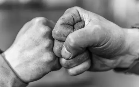 Zwei Fäuste stoßen zusammen, ein Zeichen von Solidarität und Verbundenheit.