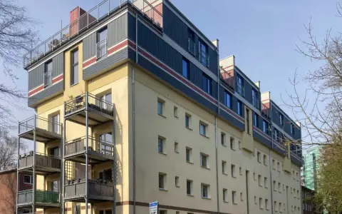 Modernes Mehrfamilienhaus mit Balkonen und auffälliger Fassadengestaltung im **Vorort**.
