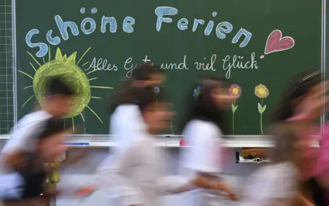 Schöne Ferien! Kinder freuen sich auf die Osterferien 2026 in NRW. Die Tafel zeigt Sonne, Blumen und ein Herz.