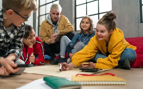 Kinder und Jugendliche arbeiten begeistert an einem Projekt. Der **Präsenzunterricht** fördert Kreativität und Teamwork.