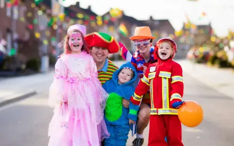 Fröhliche Familie in Kostümen feiert Fasching. Wann sind Faschingsferien in Baden-Württemberg 2026?