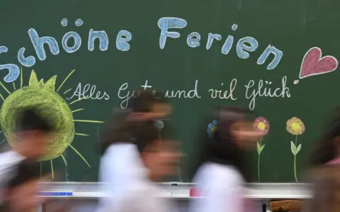 Kreidetafel mit "Schöne Ferien" und einem lachenden Smiley, bereit für die herbstferien 2025 nrw. Kinder huschen vorbei.