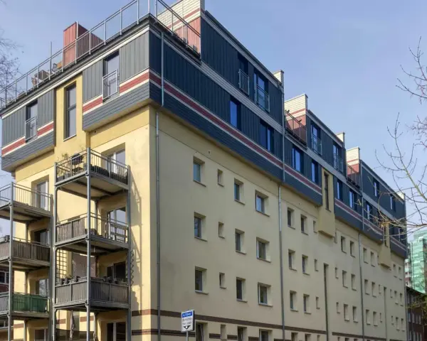 Modernes Mehrfamilienhaus mit Balkonen und auffälliger Fassadengestaltung im **Vorort**.