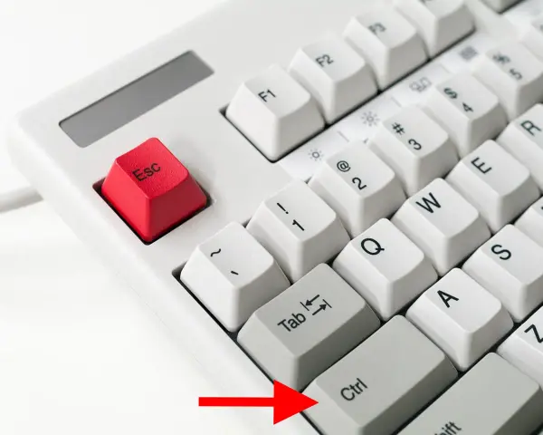 Die rote Esc-Taste und die Ctrl-Taste auf einer weißen Tastatur. Ein roter Pfeil zeigt auf die Ctrl-Taste.
