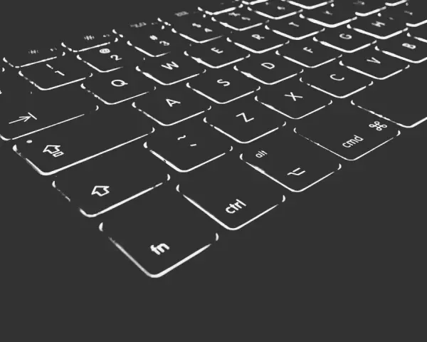 Nahaufnahme einer beleuchteten Tastatur. Die Tasten sind mit weißen Symbolen und Buchstaben versehen, die im Dunkeln leuchten. Die "Umschalt"-Taste ist deutlich zu erkennen.
