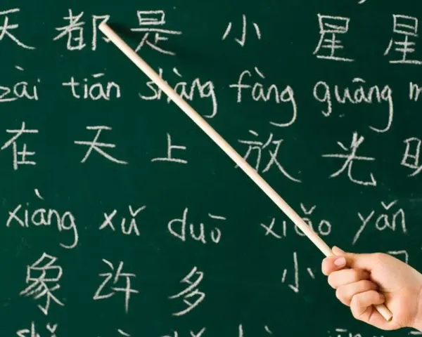 Kreide auf Tafel: Chinesische Schriftzeichen und Pinyin. Manche sagen, Chinesisch sei die schwerste Sprache der Welt.