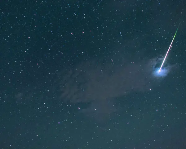 Ein leuchtender Schweif zieht sich durch den sternenklaren Nachthimmel, ein Zeichen für die magischen sternschnuppen.