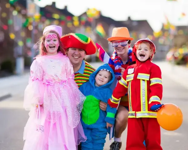 Fröhliche Familie in Kostümen feiert Fasching. Wann sind Faschingsferien in Baden-Württemberg 2026?