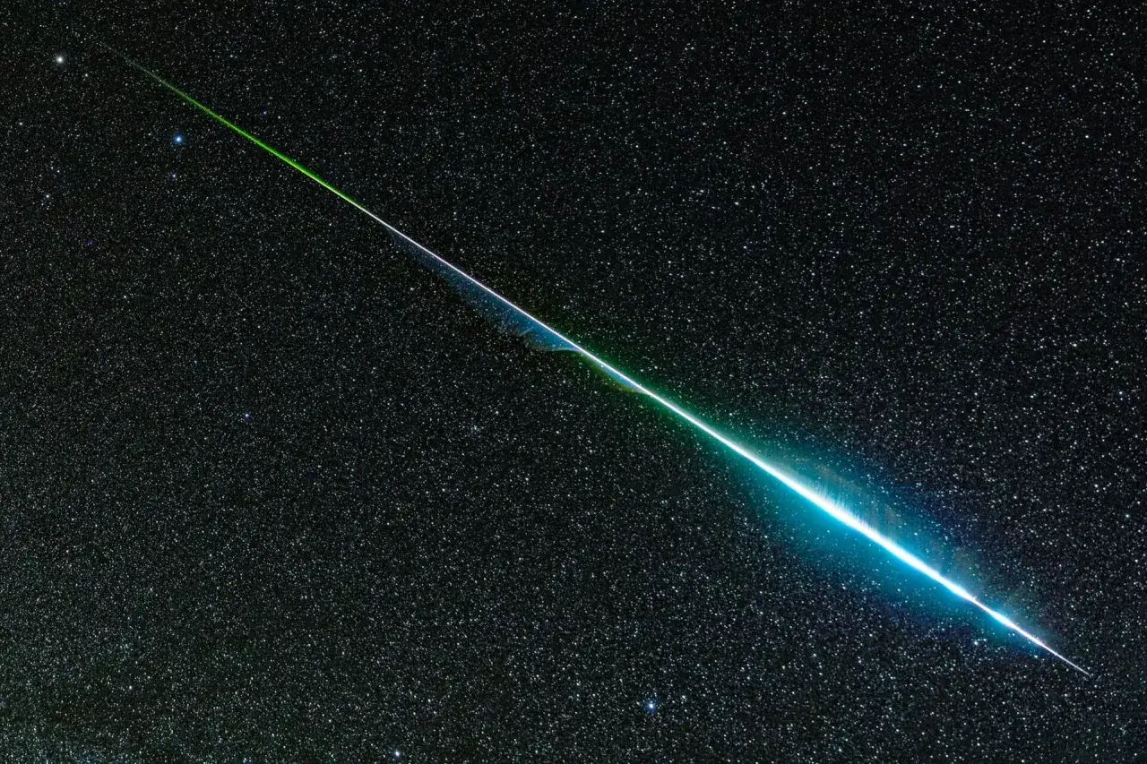 Ein leuchtender grüner und blauer Streifen, der an einen Sternenhimmel erinnert, zieht sich diagonal über das Bild. Ein magischer Moment, um Sternschnuppen zu beobachten.