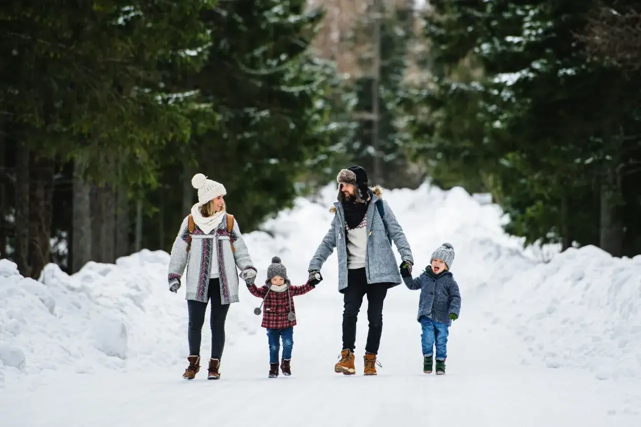 Familie genießt die Faschingsferien Bayern 2027 bei einem Spaziergang durch verschneite Wälder.