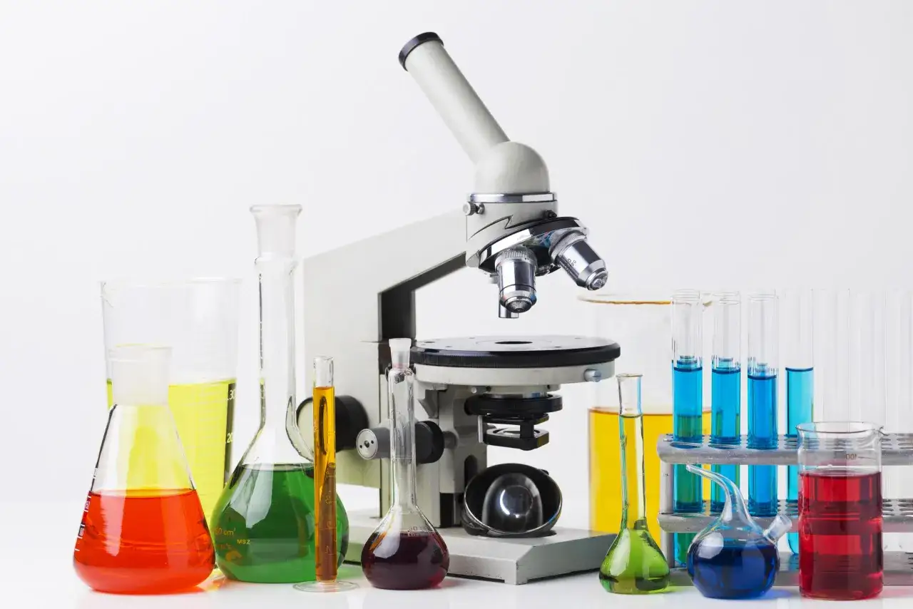 Mikroskop und bunte Flüssigkeiten in Laborgeräten. Diese Infrastruktur ermöglicht wissenschaftliche Entdeckungen.