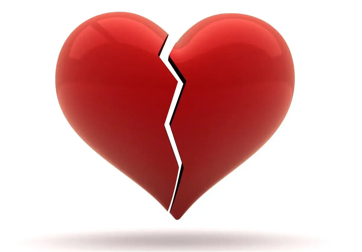 Ein zerbrochenes rotes Herz, das den Schmerz von Liebeskummer symbolisiert.