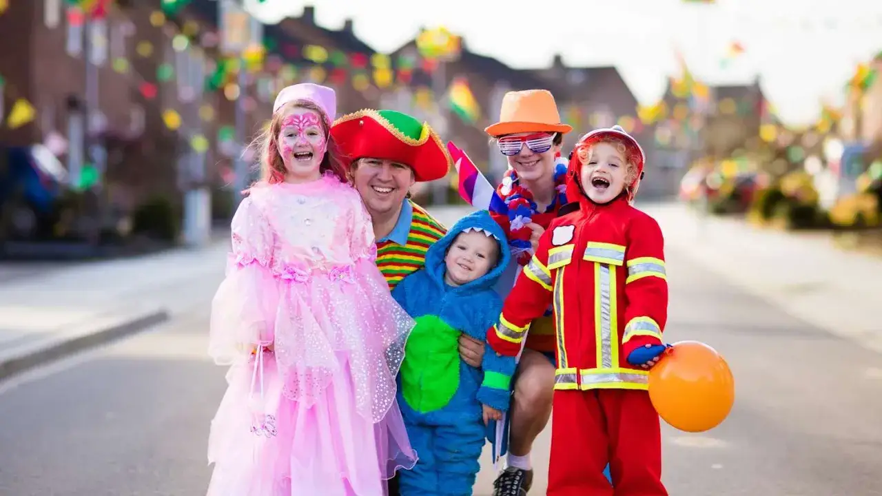 Fröhliche Familie in Kostümen feiert Fasching. Wann sind Faschingsferien in Baden-Württemberg 2026?