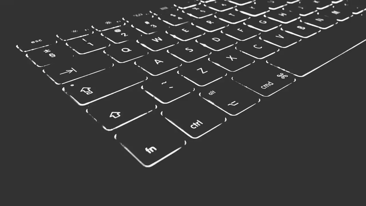 Nahaufnahme einer beleuchteten Tastatur. Die Tasten sind mit weißen Symbolen und Buchstaben versehen. Die 