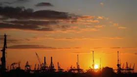 Silhouetten von Kränen im Hamburger Hafen bei Sonnenuntergang. Perfekt für die Pfingstferien in Hamburg.